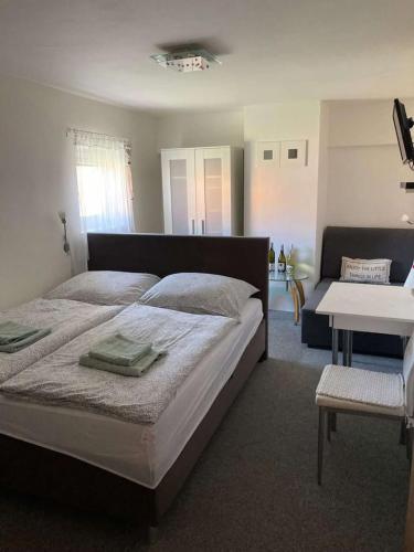 a bedroom with a large bed and a living room at Rodinný penzion in Mikulov