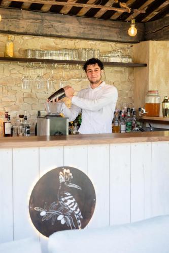 a man standing behind a counter in a kitchen at LA FERME DE LA HUPPE in Gordes