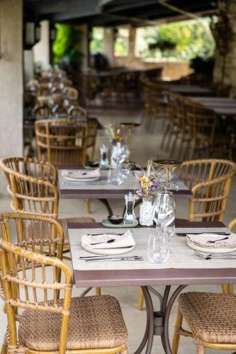 a row of tables and chairs with plates and glasses at LA FERME DE LA HUPPE in Gordes