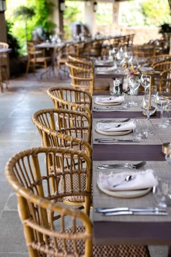a row of tables and chairs with plates and wine glasses at LA FERME DE LA HUPPE in Gordes