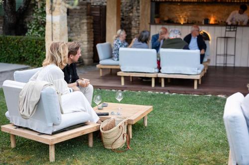 a group of people sitting on chairs in a yard at LA FERME DE LA HUPPE in Gordes