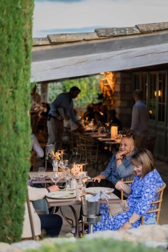 a group of people sitting at tables in a restaurant at LA FERME DE LA HUPPE in Gordes