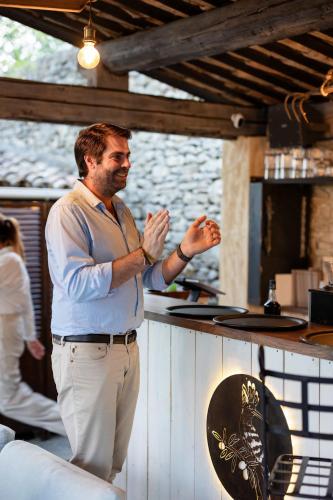 a man standing behind a counter with his hands at LA FERME DE LA HUPPE in Gordes