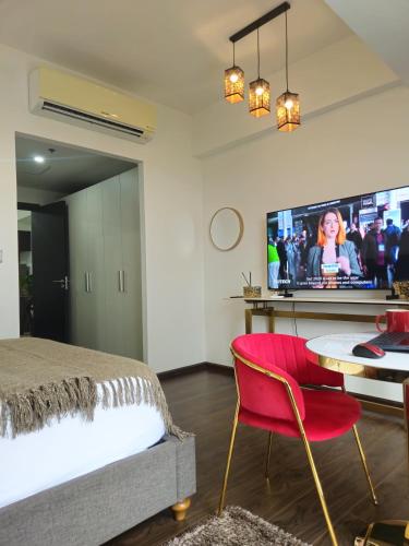a bedroom with a bed and a table and a tv at Aeon Towers Luxury Suites in Davao City