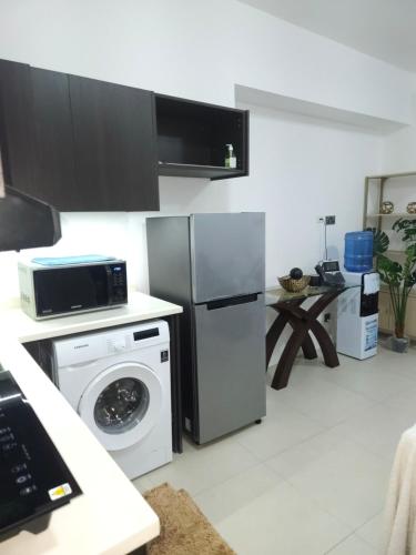 a kitchen with a refrigerator and a washing machine at Aeon Towers Luxury Suites in Davao City
