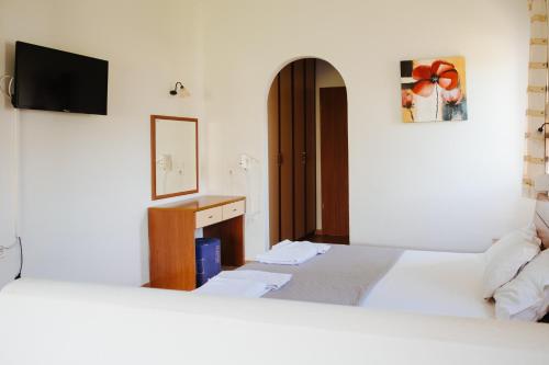 a hotel room with two beds and a mirror at Finikas Apartments in Plakias