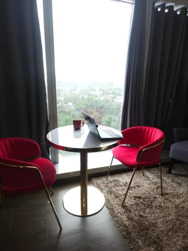 a table with a laptop on it in a room with a window at Aeon Towers Luxury Suites in Davao City