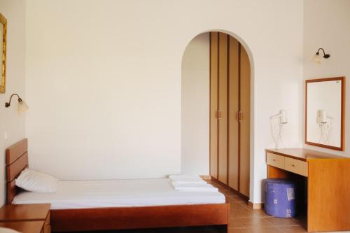 a small room with two beds and a mirror at Finikas Apartments in Plakias
