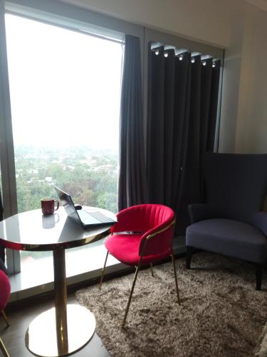 a room with a table and a red chair and a window at Aeon Towers Luxury Suites in Davao City