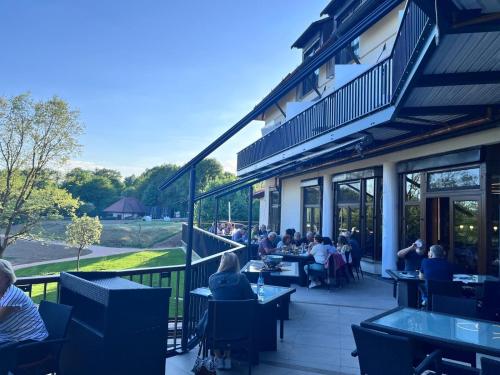 a group of people sitting at tables on a patio at Flair Park Hotel Ilshofen in Ilshofen