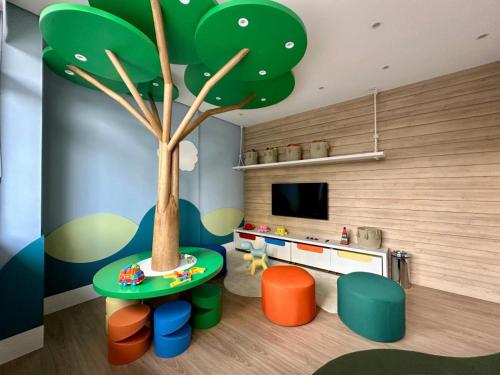 a childs room with a tree and a table and chairs at GRU Airport 4km, 2 Dorms, Bosque Maia in Guarulhos