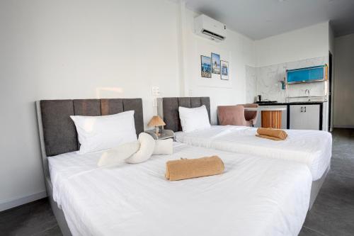 two beds in a room with white sheets and pillows at Rainbow Beach Mũi Né - Homestay & Coffee in Ấp Khánh Phước (1)