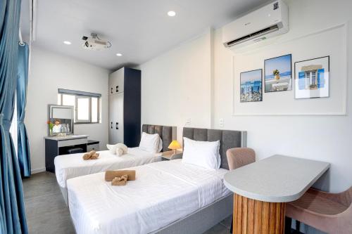 a hotel room with two beds and a table at Rainbow Beach Mũi Né - Homestay & Coffee in Ấp Khánh Phước (1)