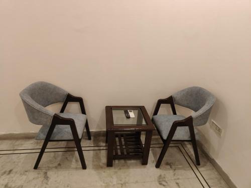 two chairs sitting next to a table with a mirror at Maira Retreat in Faridabad