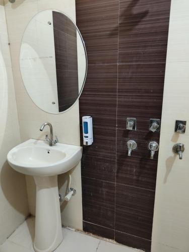 a bathroom with a sink and a mirror at Maira Retreat in Faridabad