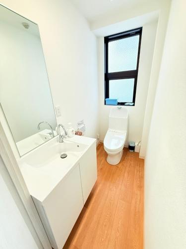 a bathroom with a white sink and a toilet at Tokyo Holiday Hotel in Tokyo