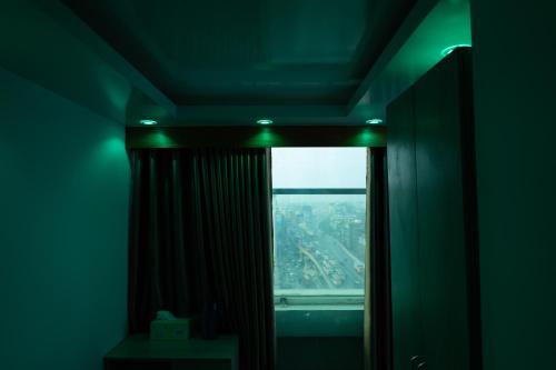 a room with a window with a view of a city at Hotel Uttara in Bāiljuri