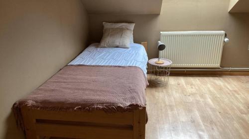 a small bedroom with a bed and a table at Cornelia in Somme-Leuze