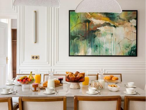 une salle à manger avec une table avec des fruits et un tableau dans l'établissement Merveil - Signature Suite - Marais - Caire II, à Paris