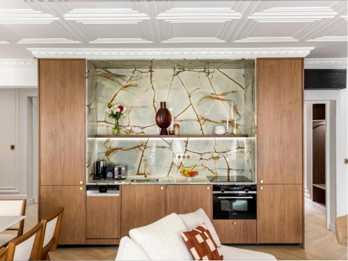 un salon avec une cuisine dotée d'armoires en bois dans l'établissement Merveil - Signature Suite - Marais - Caire II, à Paris
