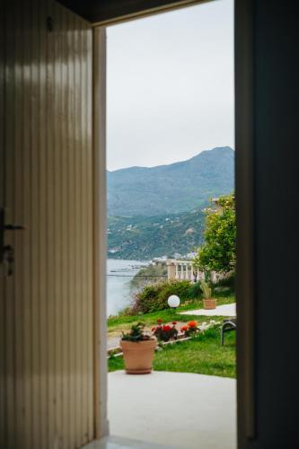 a door to a room with a view of the water at Finikas Apartments in Plakias