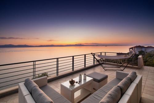 a balcony with a couch and a view of the water at Sea Whisper Villa Peloponnese in Arkadiko Chorio