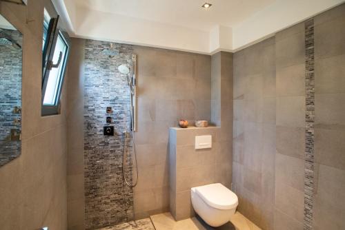 a bathroom with a toilet and a shower at Sea Whisper Villa Peloponnese in Arkadiko Chorio