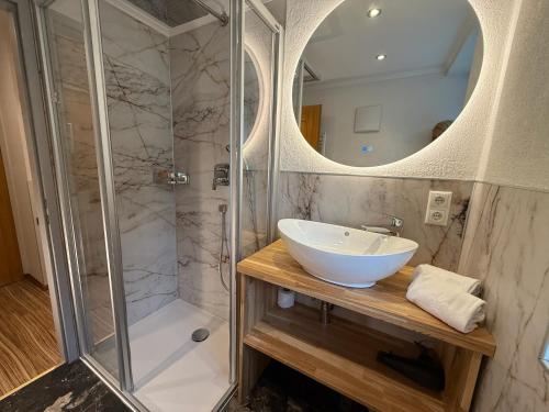 a bathroom with a sink and a shower at GRUBERS, Hotel Appartments Gastein in Bad Gastein