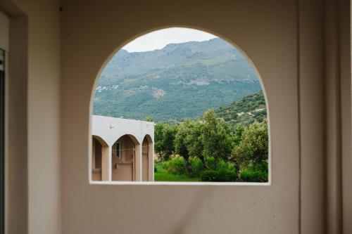 an arched window with a view of a mountain at Finikas Apartments in Plakias