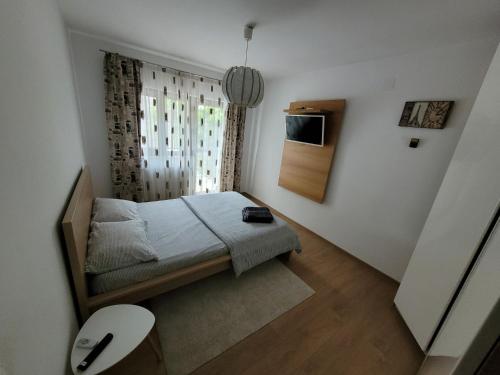 a small bedroom with a bed and a window at Vila Vati - Arena Pitesti in Piteşti