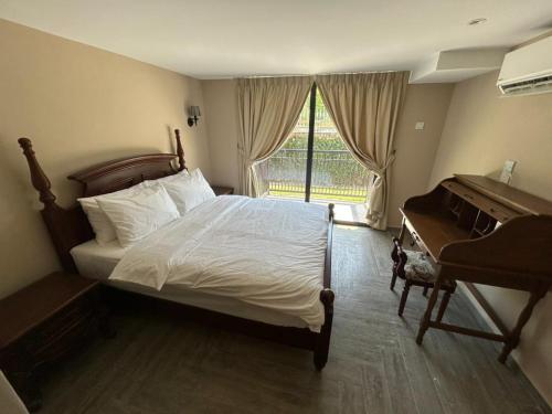 a bedroom with a bed and a desk and a piano at The Farmhouse in Ipoh