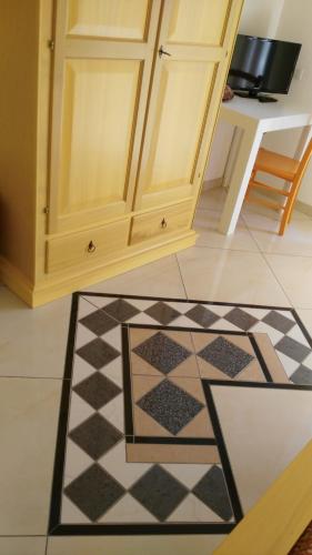 a kitchen with a checkered floor and a cabinet at B&b Sa Zodia Guest House in Bitti