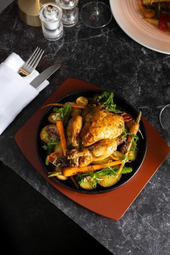 a plate of food with chicken and vegetables on a table at Melia White House Hotel in London