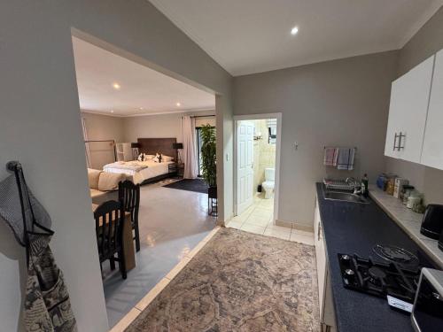 a kitchen with a sink and a bedroom with a bed at B&B At 66 Henderson in Claredon