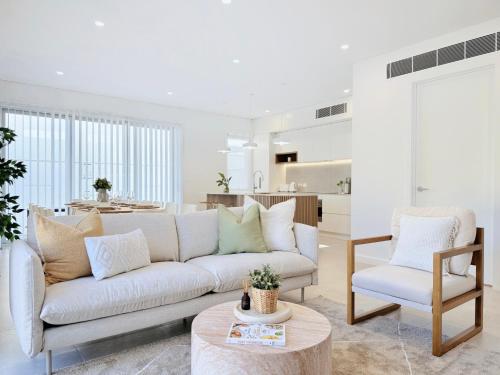 a living room with a couch and a table at Casa Sol Steps to Beach & Marina in Shellharbour