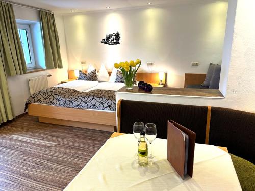 a hotel room with a bed and a table with wine glasses at GRUBERS, Hotel Appartments Gastein in Bad Gastein