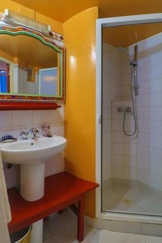 a bathroom with a sink and a shower with a mirror at Les Matins Bleus in Essaouira