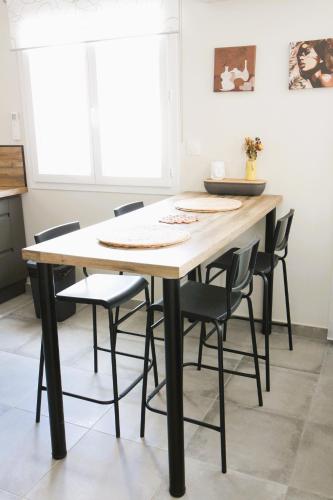 d'une table à manger entourée de chaises noires. dans l'établissement Maison T3, à Sallèles-dʼAude