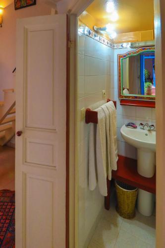 a bathroom with a sink and a toilet and a mirror at Les Matins Bleus in Essaouira