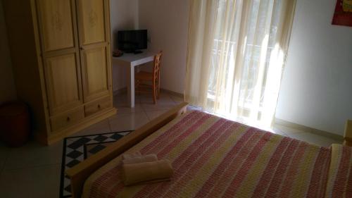 a bedroom with a bed and a window and a table at B&b Sa Zodia Guest House in Bitti