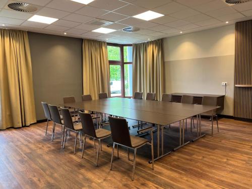 a conference room with a large table and chairs at Flair Park Hotel Ilshofen in Ilshofen