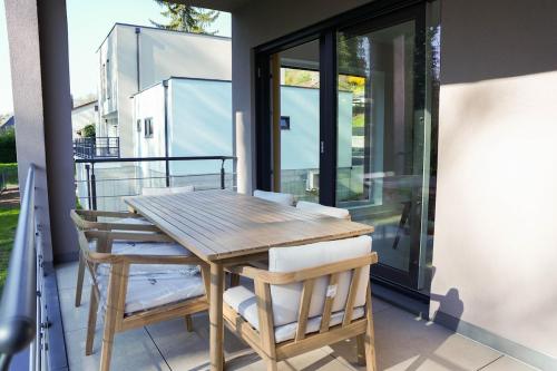 une table en bois et deux chaises sur un balcon dans l'établissement Superbe maison au calme avec stationnement gratuit, à Mulhouse