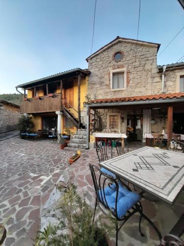 a patio with a table and chairs in front of a building at Hostel Xaxid in Črni Kal