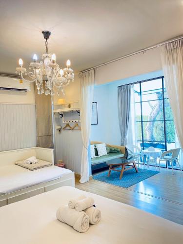 a bedroom with two beds and a living room at La Riva Boutique Hotel in Kamphaeng Phet