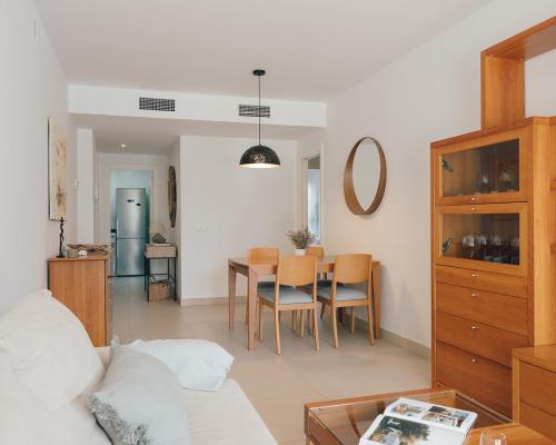 a living room with a table and a dining room at Marina Real I - Casa Areca in Denia