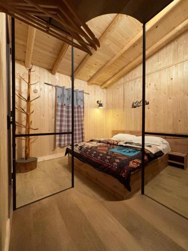 a bedroom with a bed in a room with wooden walls at Etna Chalet Nicolosi in Nicolosi