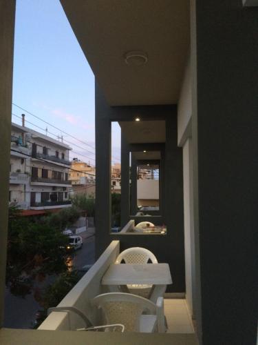 a balcony with two chairs and a table on a building at Kleri Beloni Rooms in Chania Town