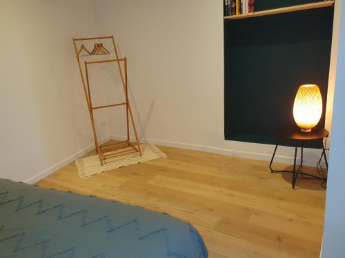 a room with a tv and a lamp and a table at La Margotte in Voiron