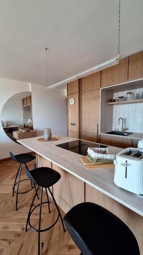- une cuisine avec 2 chaises et un comptoir avec évier dans l'établissement Appartement design 1ère ligne avec vue panoramique sur la mer, à Cannes