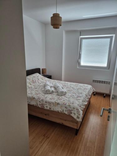 a bedroom with a bed with a floral bedspread at Apartments 402 in Bar